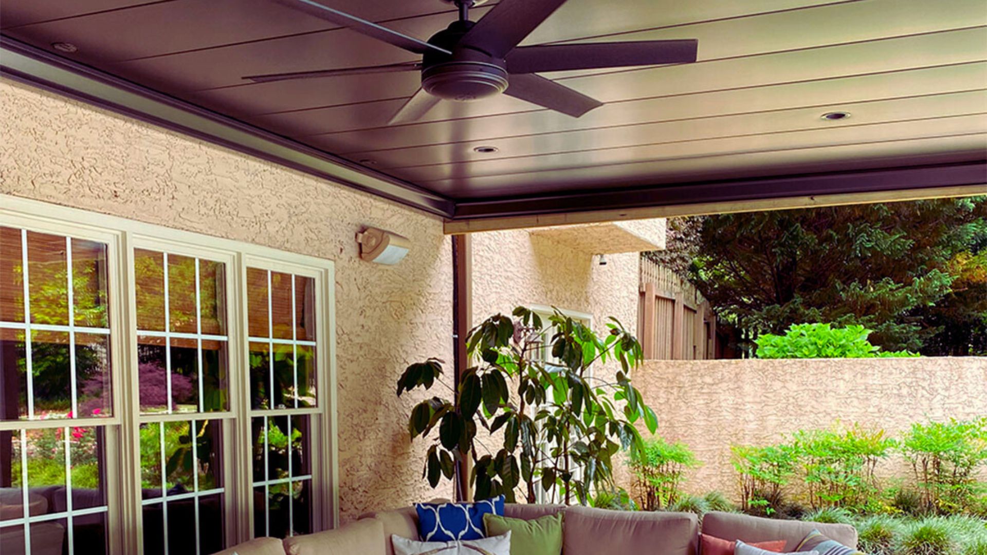 A cozy patio featuring a ceiling fan and a comfortable couch for relaxation.