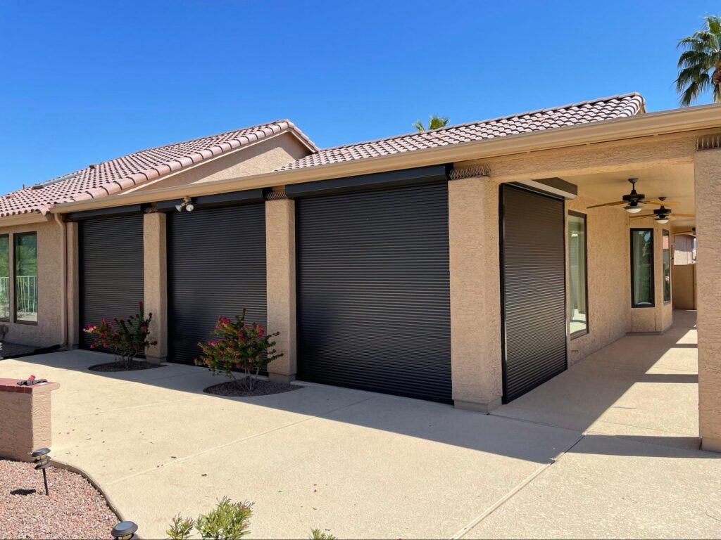 A house featuring black roller shades on the front windows, enhancing its modern appearance.