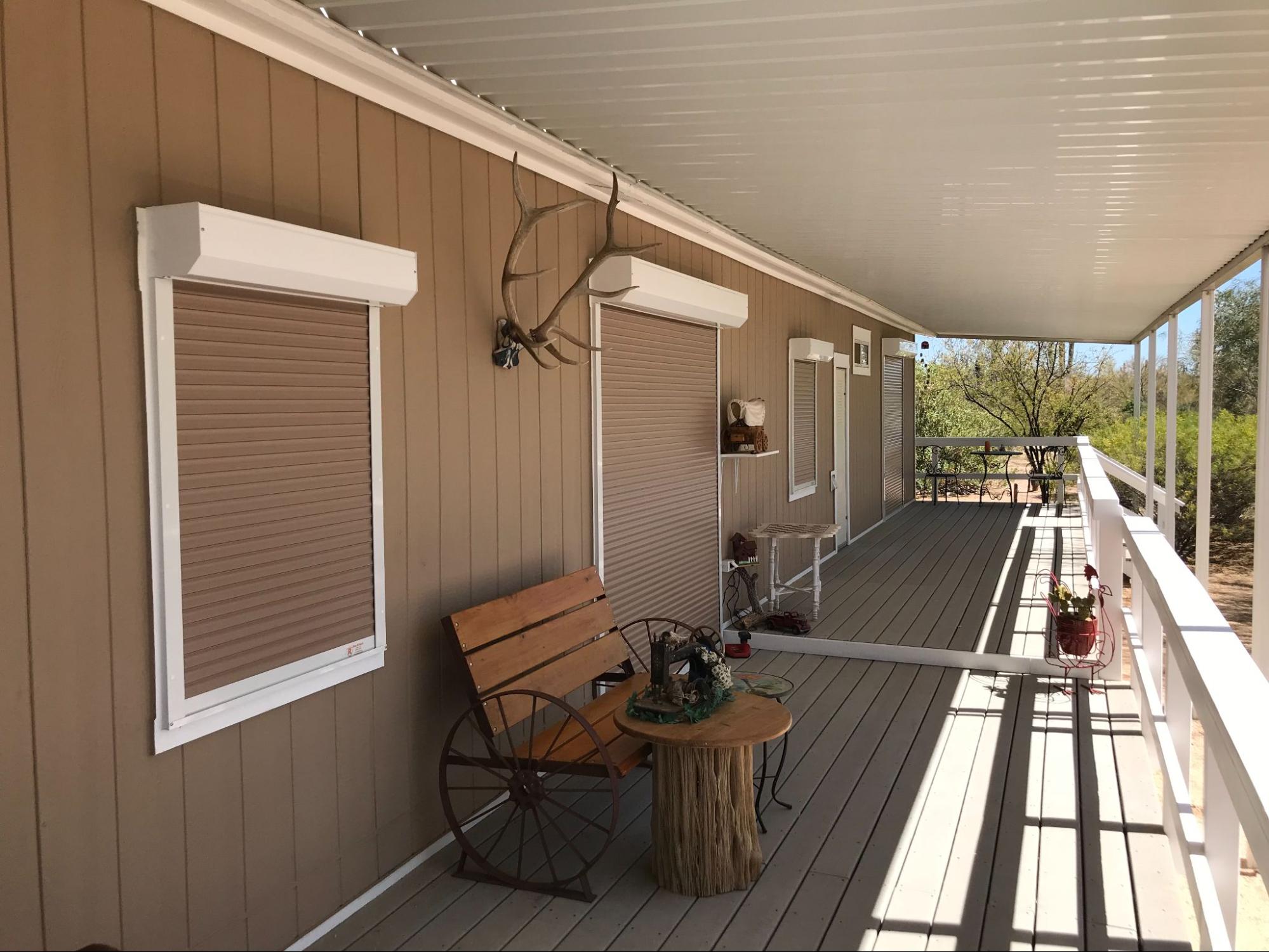 A porch featuring a wooden bench beside a window, creating a cozy outdoor seating area.